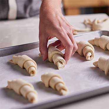 fresh croissant dough rolled on sheet pan